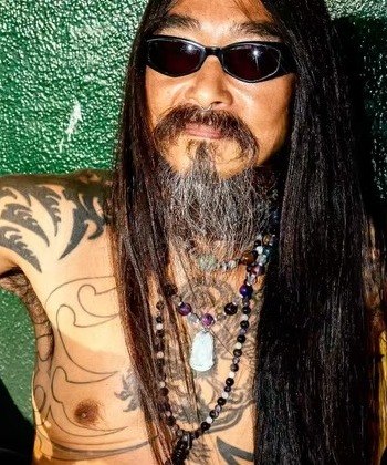 Close portrait of a smiling man with face and neck tattoos on the Santa Monica boardwalk